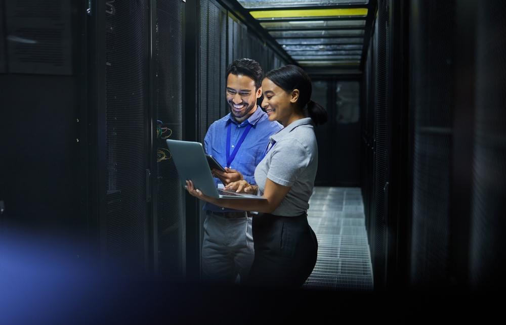 IT professionals collaborating in a secure data centre with laptop