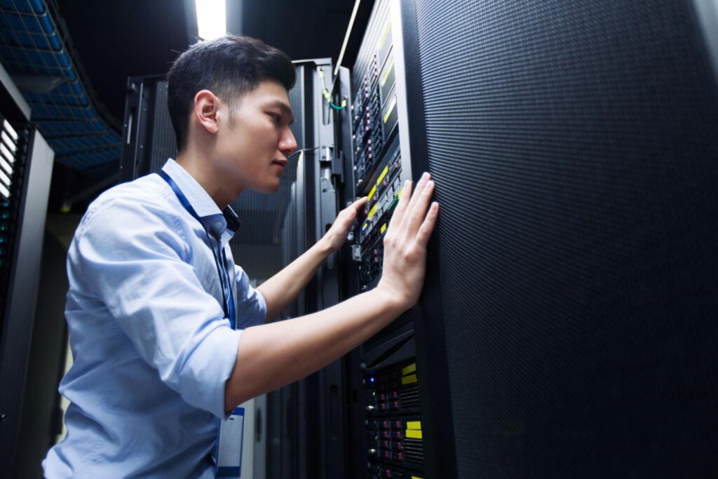 Data centre technician checking server rack equipment